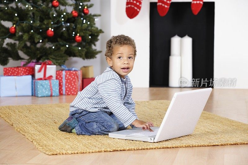 混血小孩/婴儿在圣诞节使用笔记本电脑